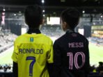 Penggemar Al-Nassr dan Inter Miami berfoto dengan nama Cristiano Ronaldo dan Lionel Messi tercetak di bagian belakang kaos mereka sebelum pertandingan Piala Musim Riyadh antara Al-Nassr dan Inter Miami di Kingdom Arena pada 01 Februari 2024 di Riyadh, Arab Saudi. (Foto oleh Yasser Bakhsh/Getty Images)