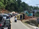 Truk sawit terguling di Tebing Alay, Empat Lawang, menyebabkan kemacetan panjang. Polisi dan warga bantu evakuasi di lokasi proyek perbaikan tebing.