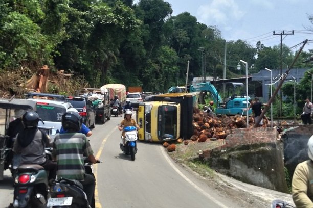 Truk sawit terguling di Tebing Alay, Empat Lawang, menyebabkan kemacetan panjang. Polisi dan warga bantu evakuasi di lokasi proyek perbaikan tebing.
